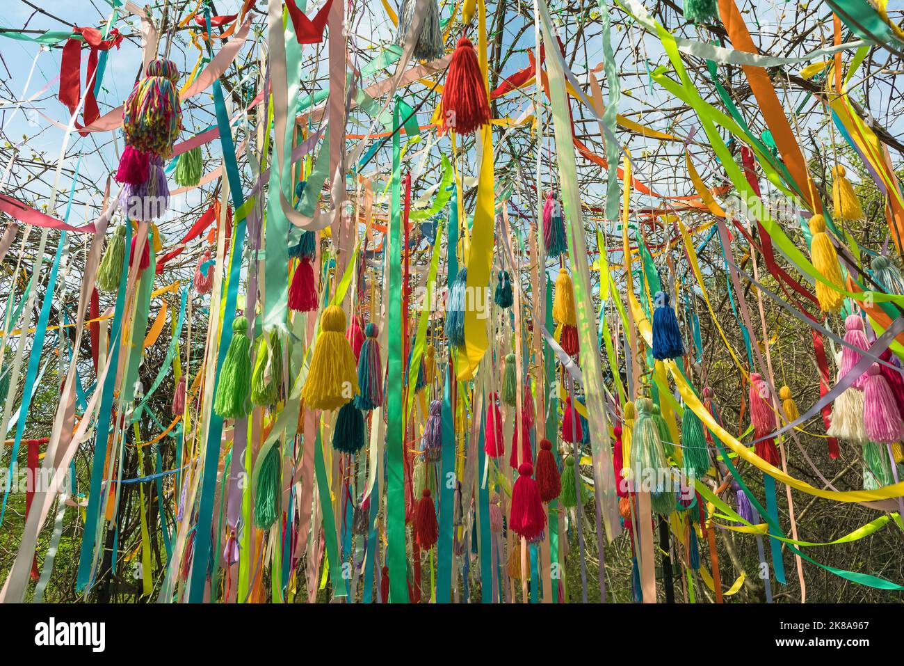 background of colorful ribbons and tassels hanging from above on sunny spring day Stock Photo