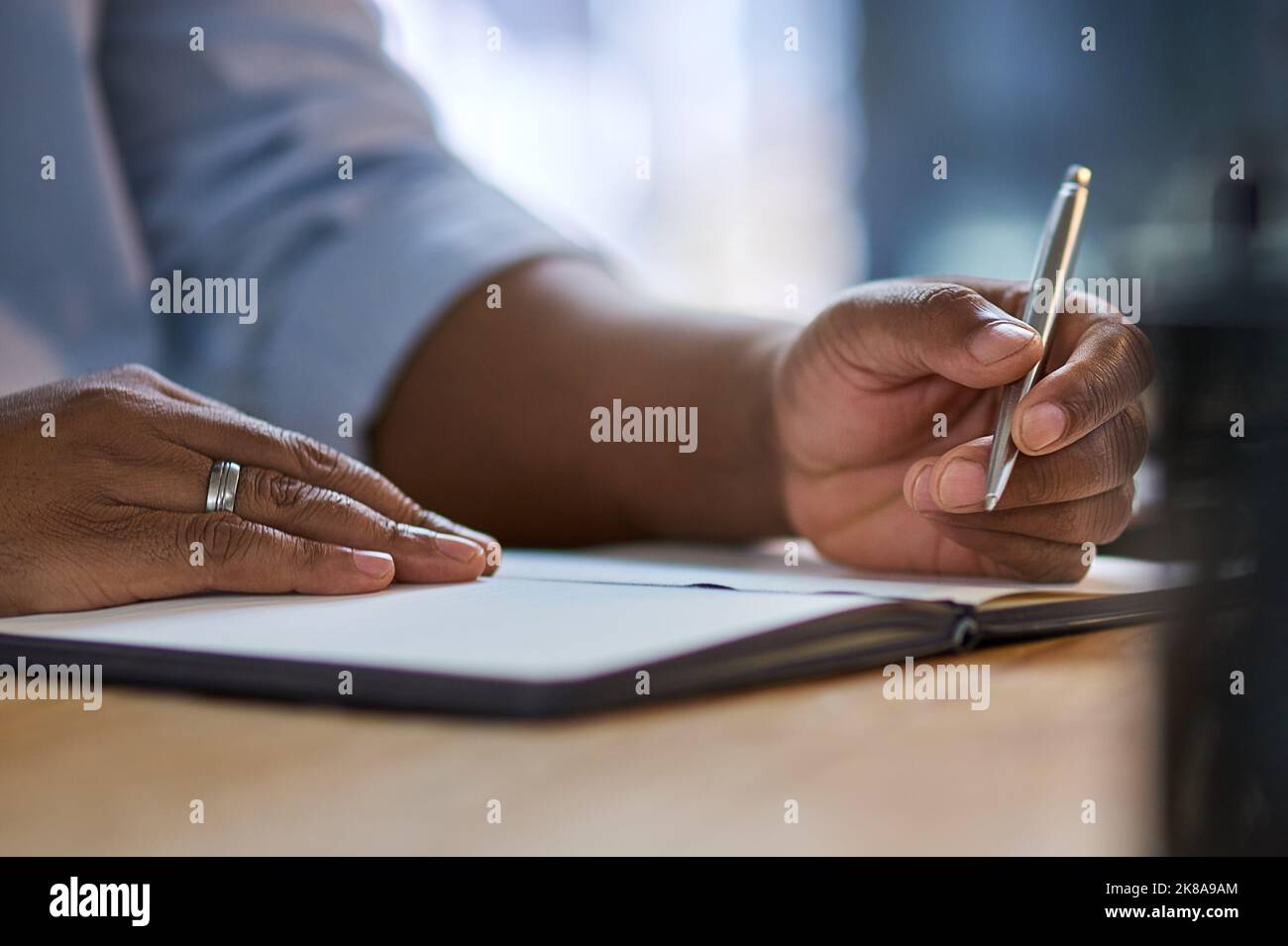 When you write down your dreams, they become tangible. an unrecognizable businessman sitting alone at his office desk at night and writing in a Stock Photo