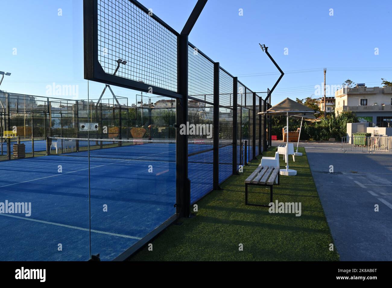 View on enclosed court for padel with construction created by mesh and the glass back walls. Stock Photo