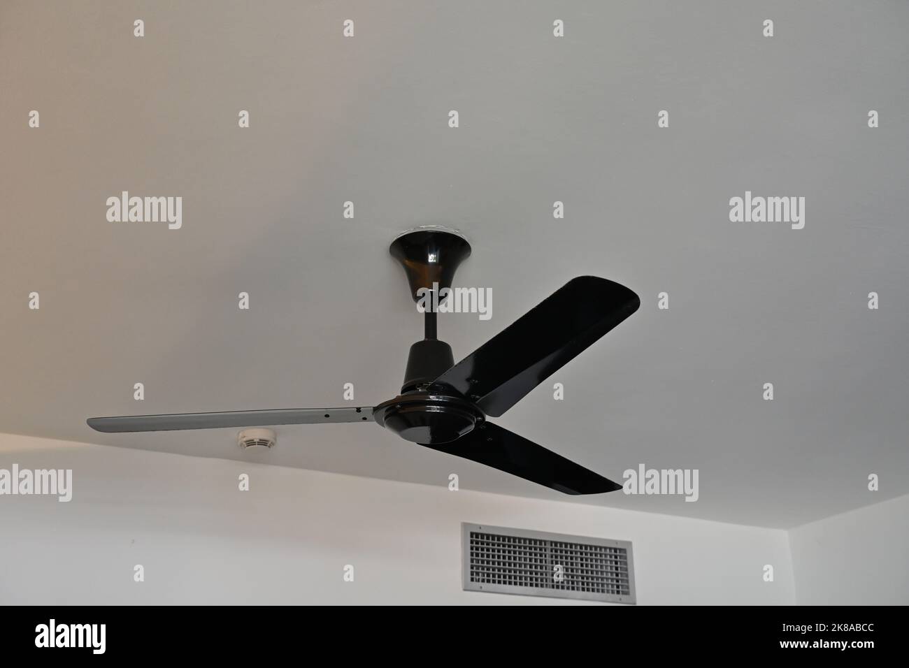 View on black ceiling fan with tree blades made from plastic installed