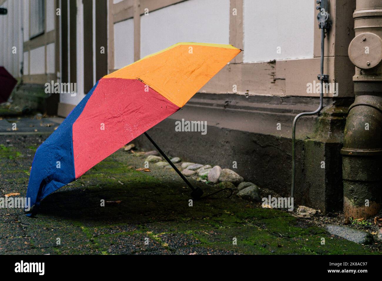 Colorful umbrella stands stretched on the ground in front of a house