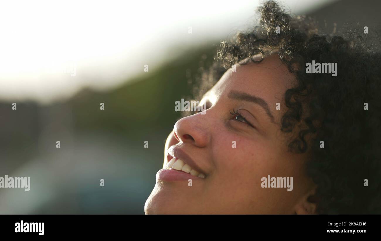 Meditative young woman opening eyes smiling to sky. One contemplative ...