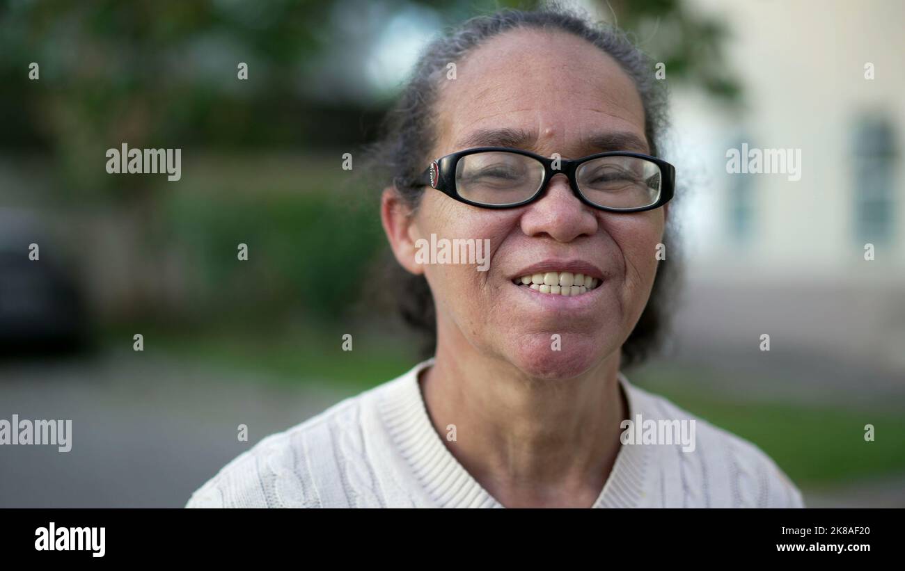 Portrait of a happy hispanic senior woman smiling at camera standing ...