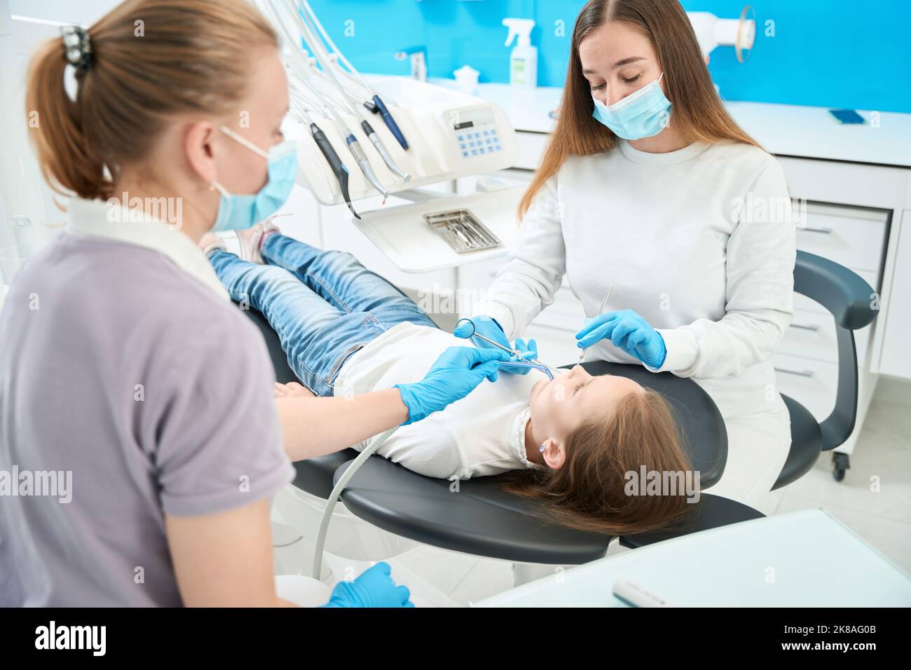 Concentrated pediatric dentist administering anesthesia to patient