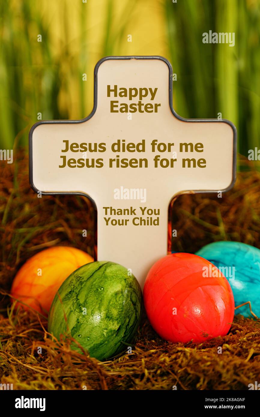 cross with eggs and the words  'happy easter - Jesus is risen' Stock Photo