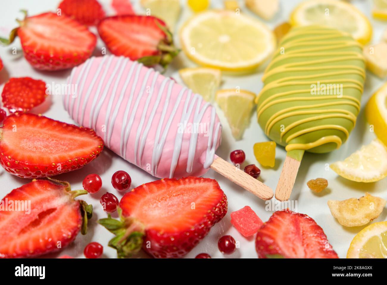Two ice creams on a sticks - strawberry and lemon on a white background. Summer fruit desserts. Stock Photo