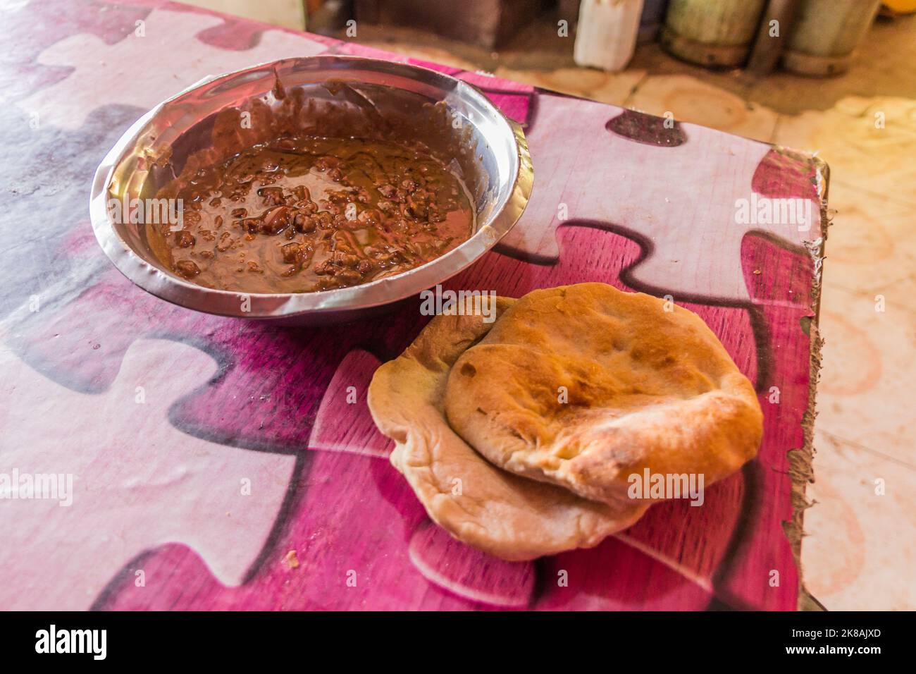 Traditional meal in Sudan - fuul (stew of cooked fava beans) and bread. Stock Photo