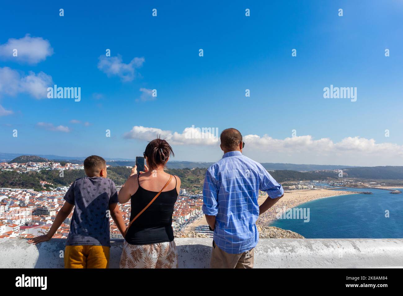 Family on vacation taking pictures of Nazaré village, Praia da Nazaré