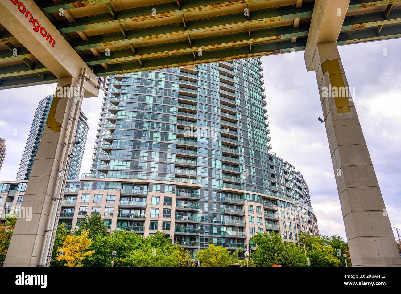 An apartment building with a modern design is framed from below the
