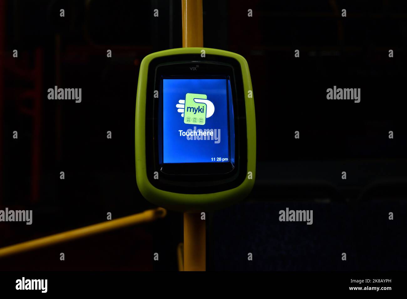 Illuminated LCD screen of a VIX Myki ticket reader, with message to passengers to touch here, on a bus late at night Stock Photo