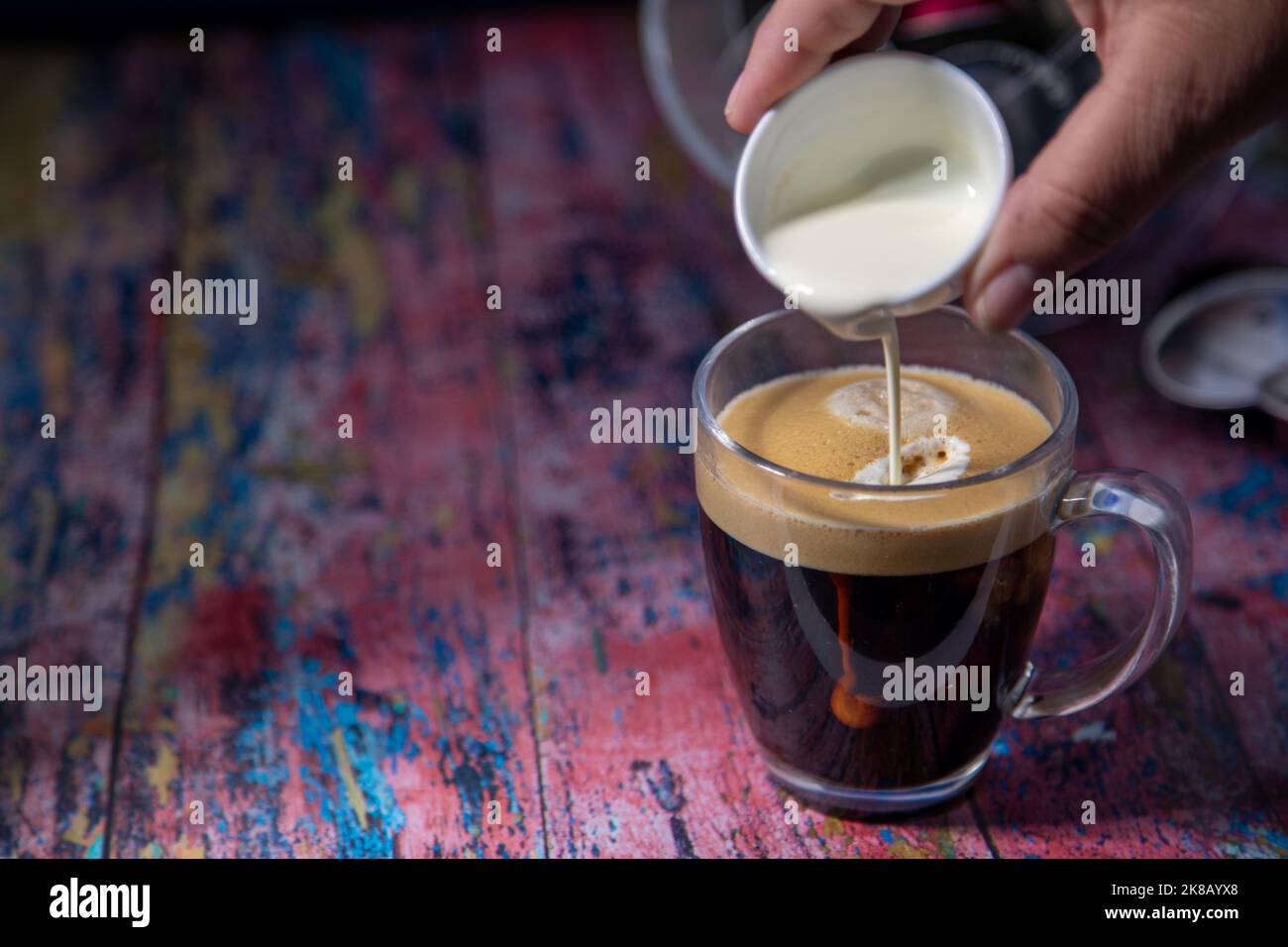 Americano With Cream Being Poured Into Drink Stock Photo - Alamy