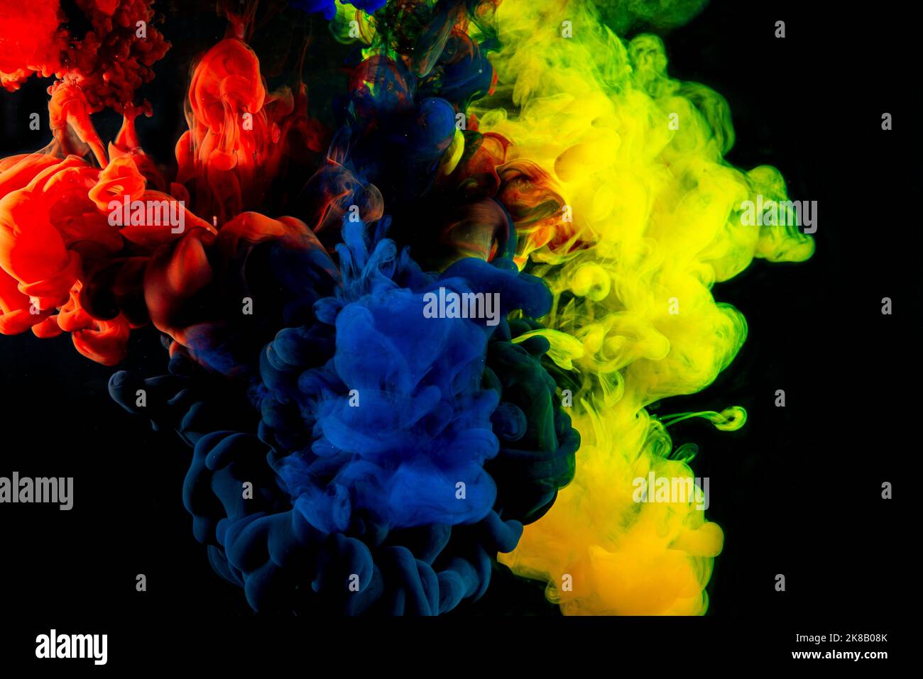 Yellow red and blue ink abstract into dark banner . Stock Photo