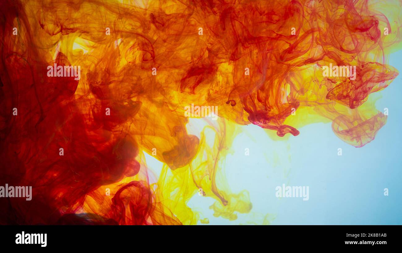 Yellow and red paint making abstract art wallpaper in white Stock Photo