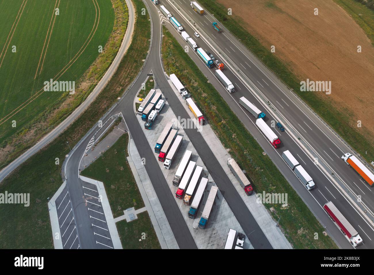 Aerial view of logistic traffic and parking lots full of trucks on highway in Poland. View from drone. Stock Photo