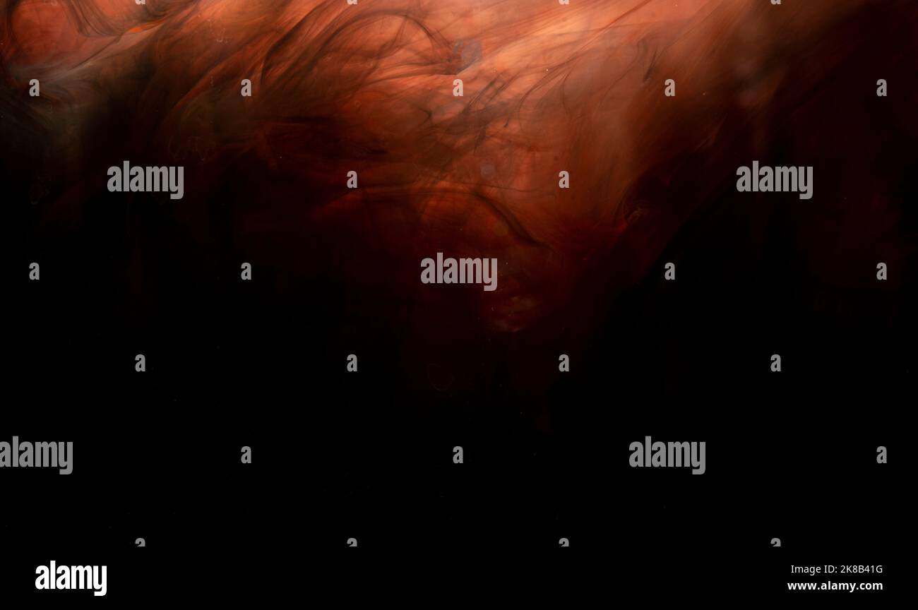 Abstract orange paint making a background wallpaper on black. Stock Photo