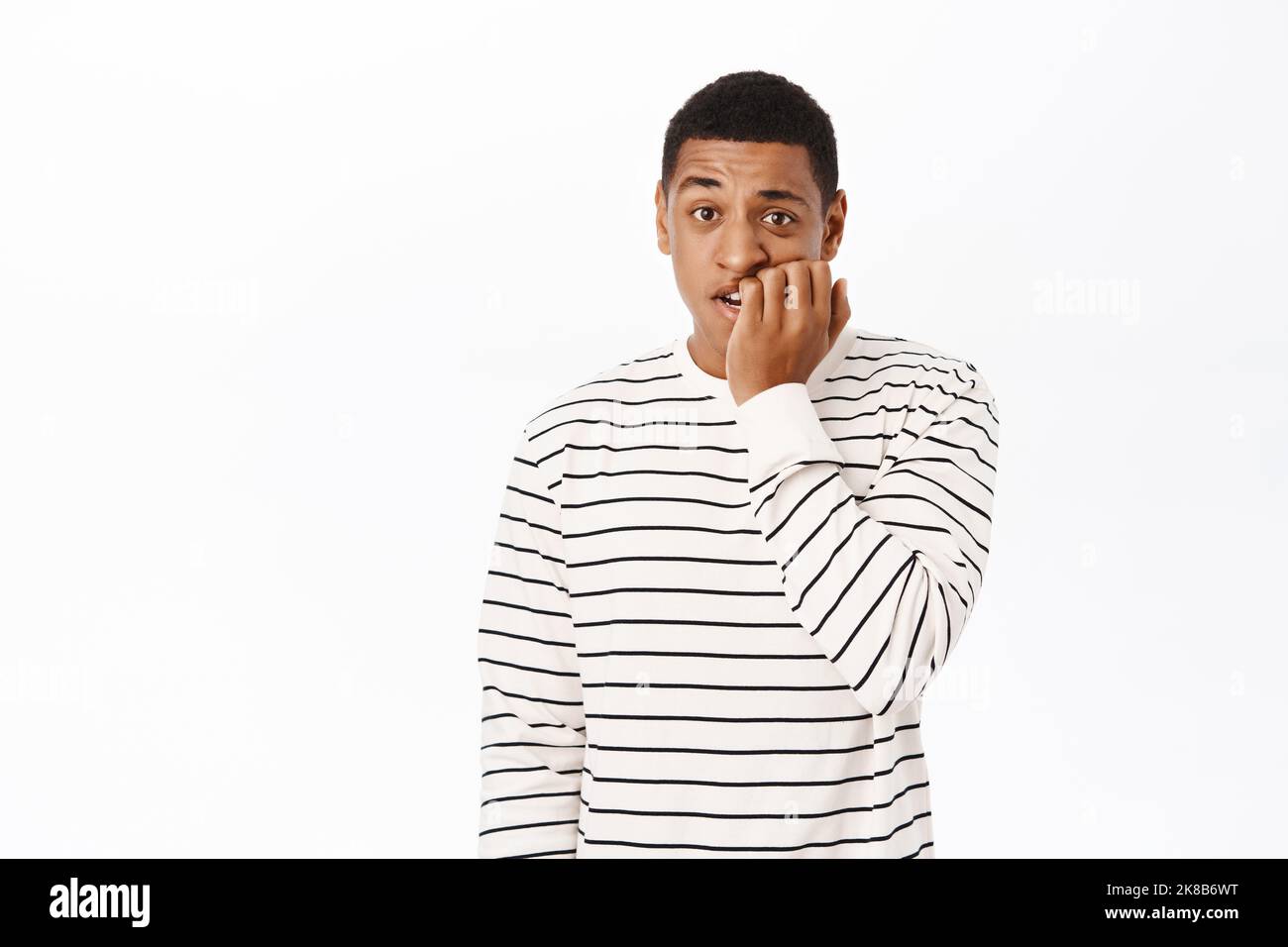 Anxious middle aged african american man, biting fingers, looking