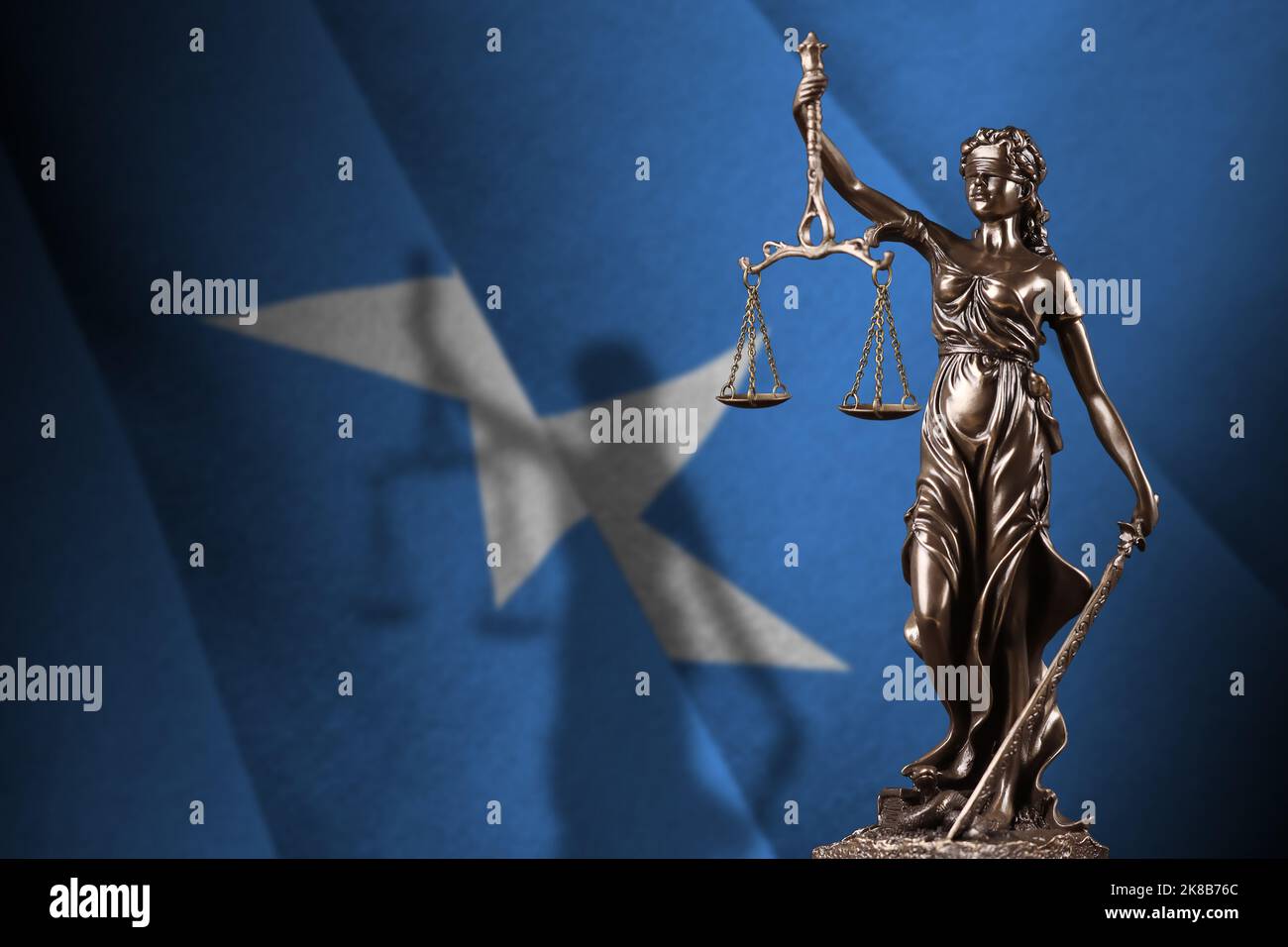 Somalia flag with statue of lady justice and judicial scales in dark room. Concept of judgement and punishment, background for jury topics Stock Photo