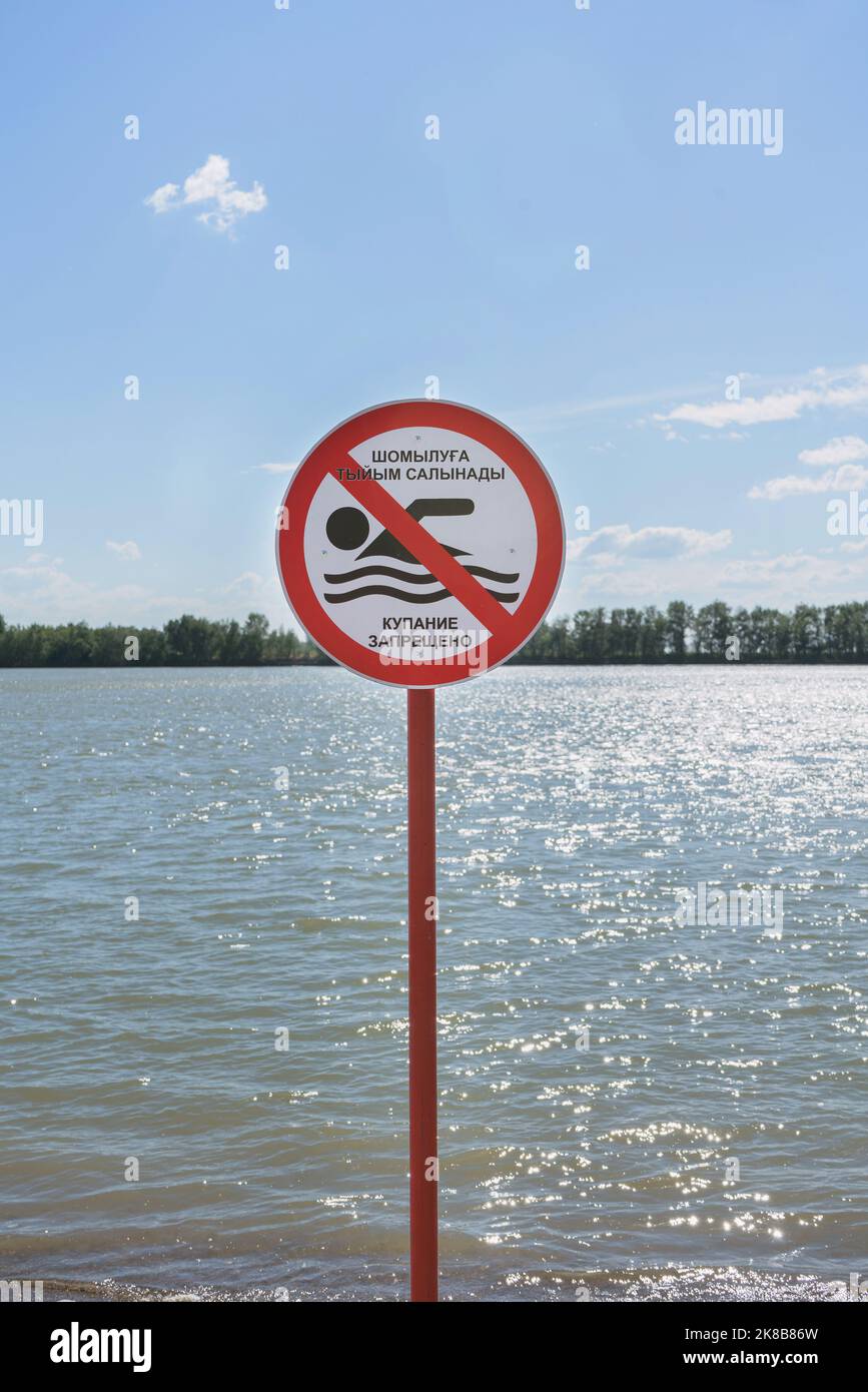 close up view of restricted sign in kazakh and russian languages for swimming ban Stock Photo