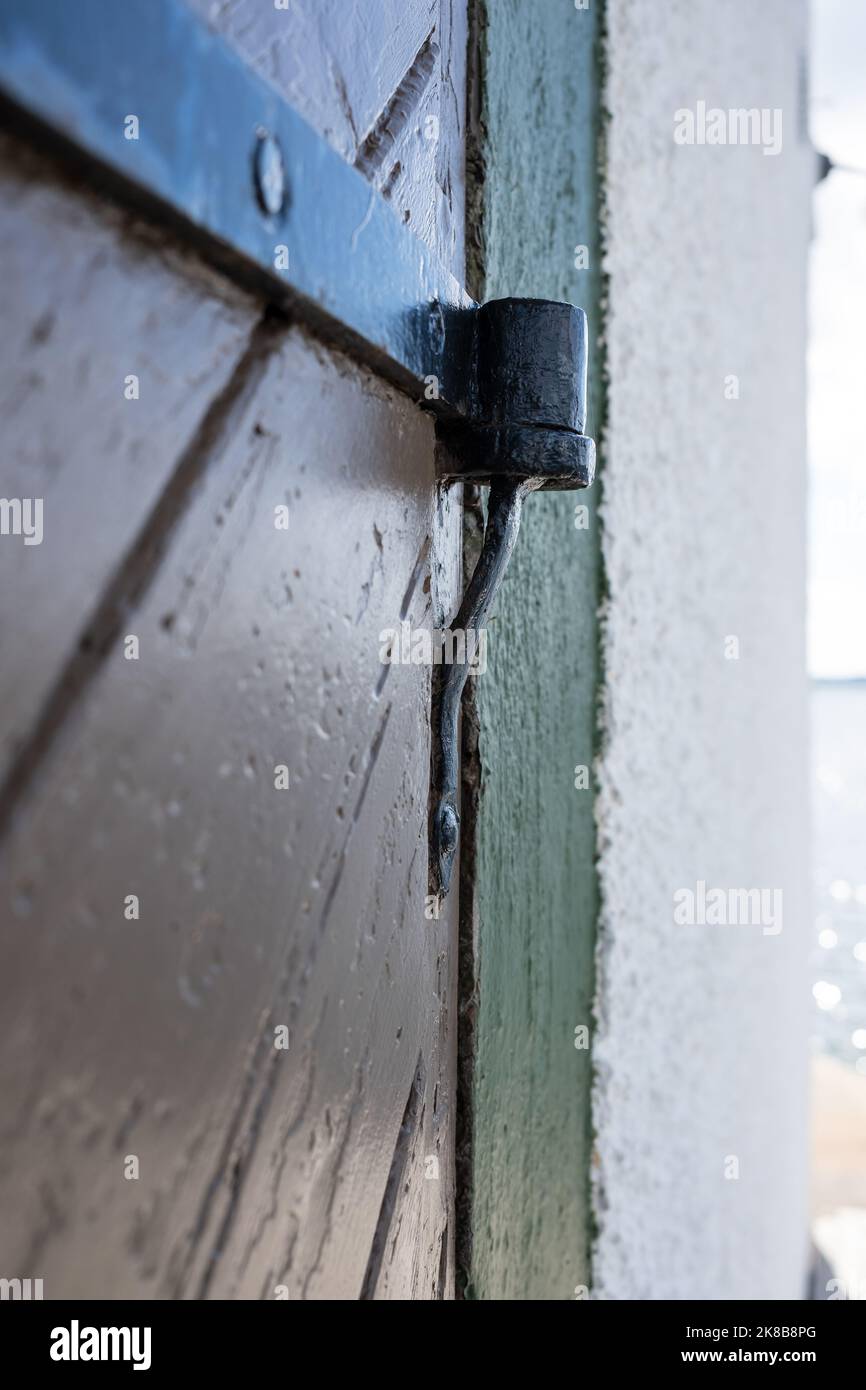 Vintage wooden door with iron hinge, outdoors. Details of architecture ...