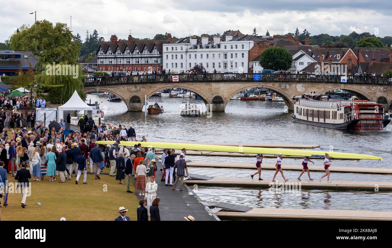Henley Royal Regatta, an annual rowing event, takes place on the River Thames.   Pictured: Rowers carry and lower their boat onto the docks ahead of t Stock Photo