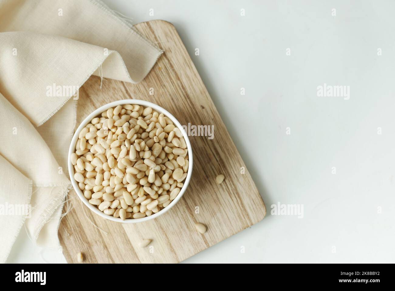 overhead view of pine nuts on a bowl on white  Stock Photo
