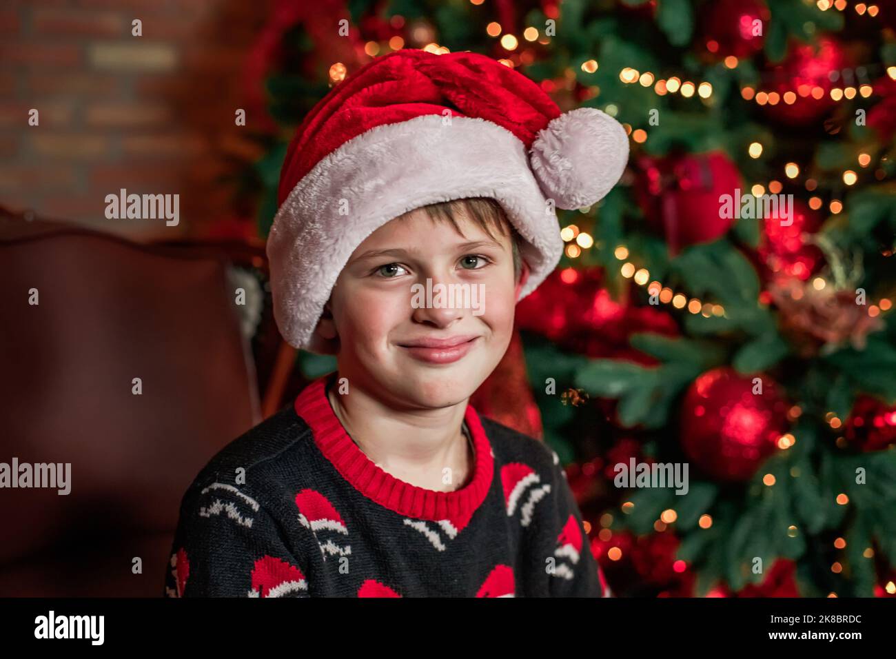 Christmas helper child in Santa Claus hat on the background of a