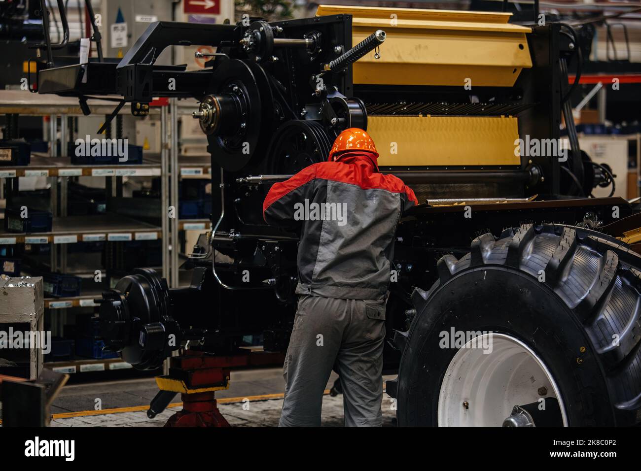 Industrial workers assembles agricultural harvester in workshop. Stock Photo
