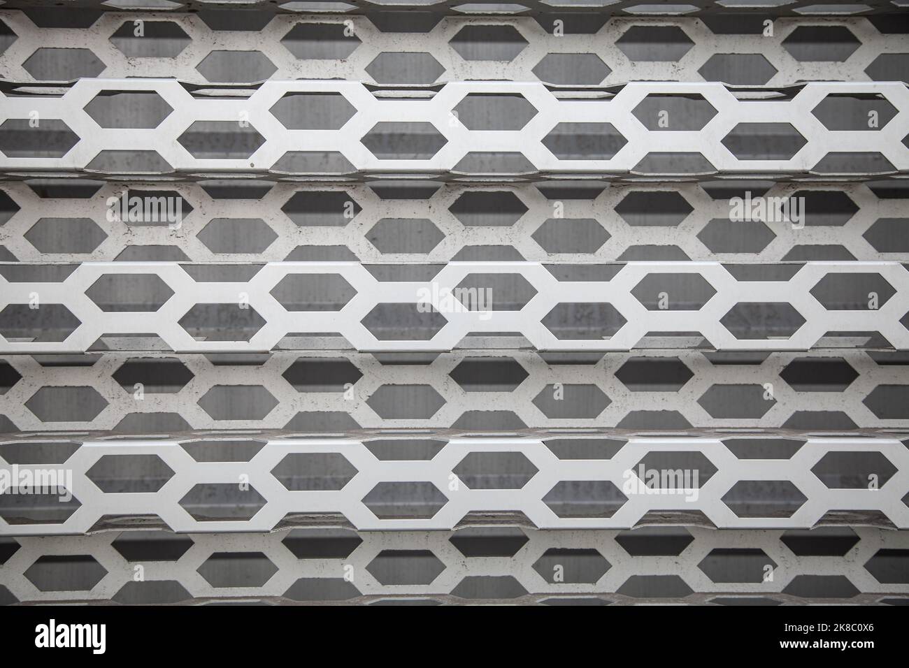 Background of wavy metallic grid with holes. Metal mesh as background. Perforated metal back. Stock Photo
