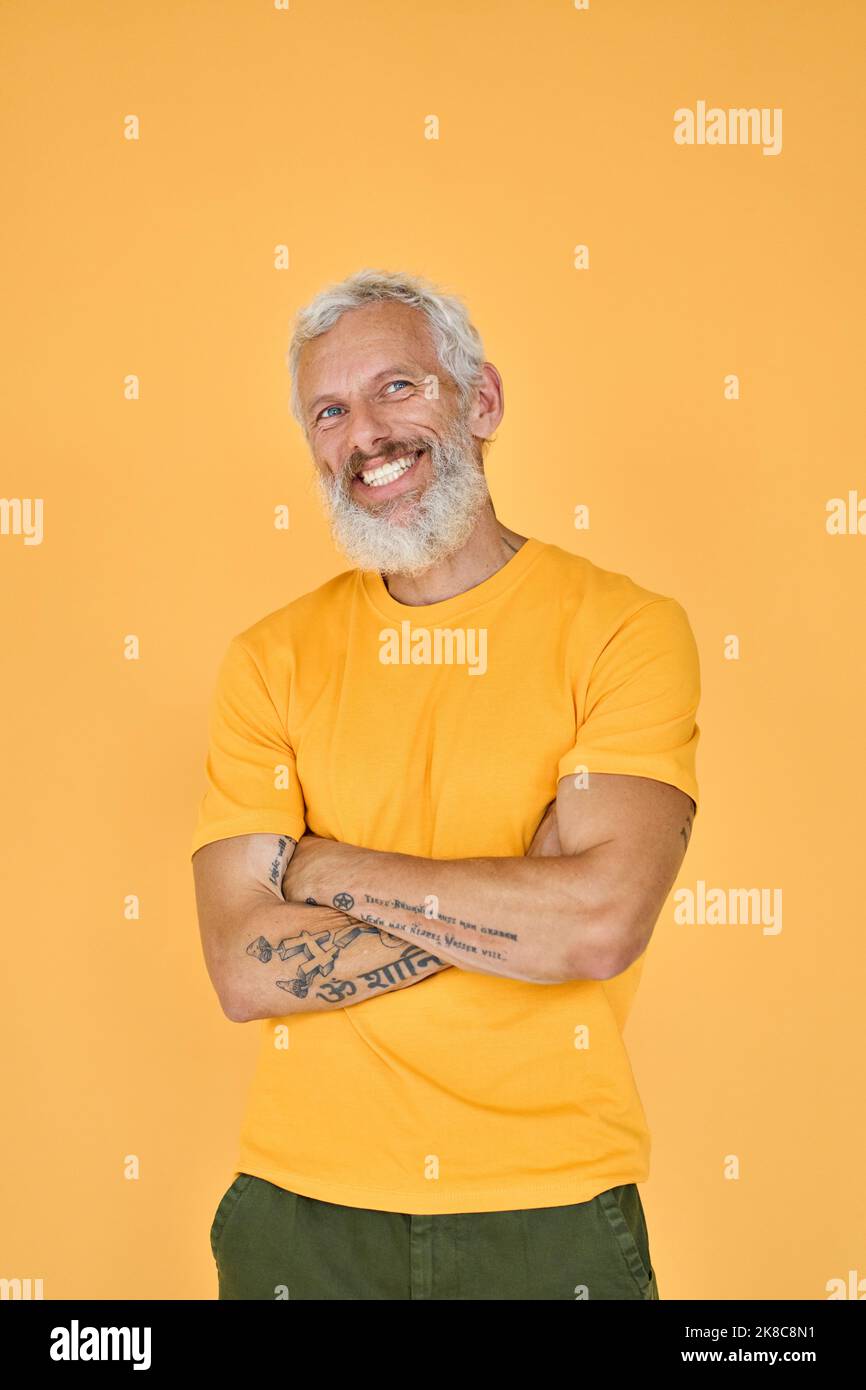 Smiling older bearded hipster man isolated on yellow background, portrait. Stock Photo