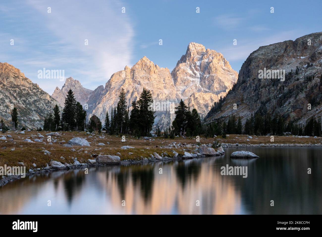 The Teton Mountains reflected in the calm waters of Lake Solitude after ...