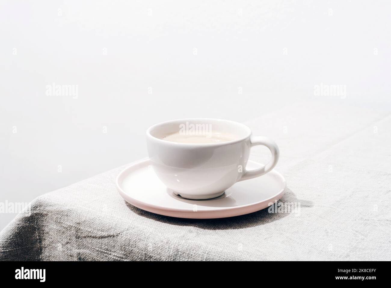 A cup of coffee on a table with tablecloth. Minimal still life. Closeup Stock Photo