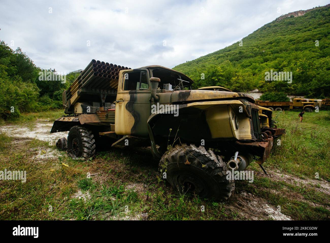 Old abandoned rusty military trucks overgrown by plants Stock Photo