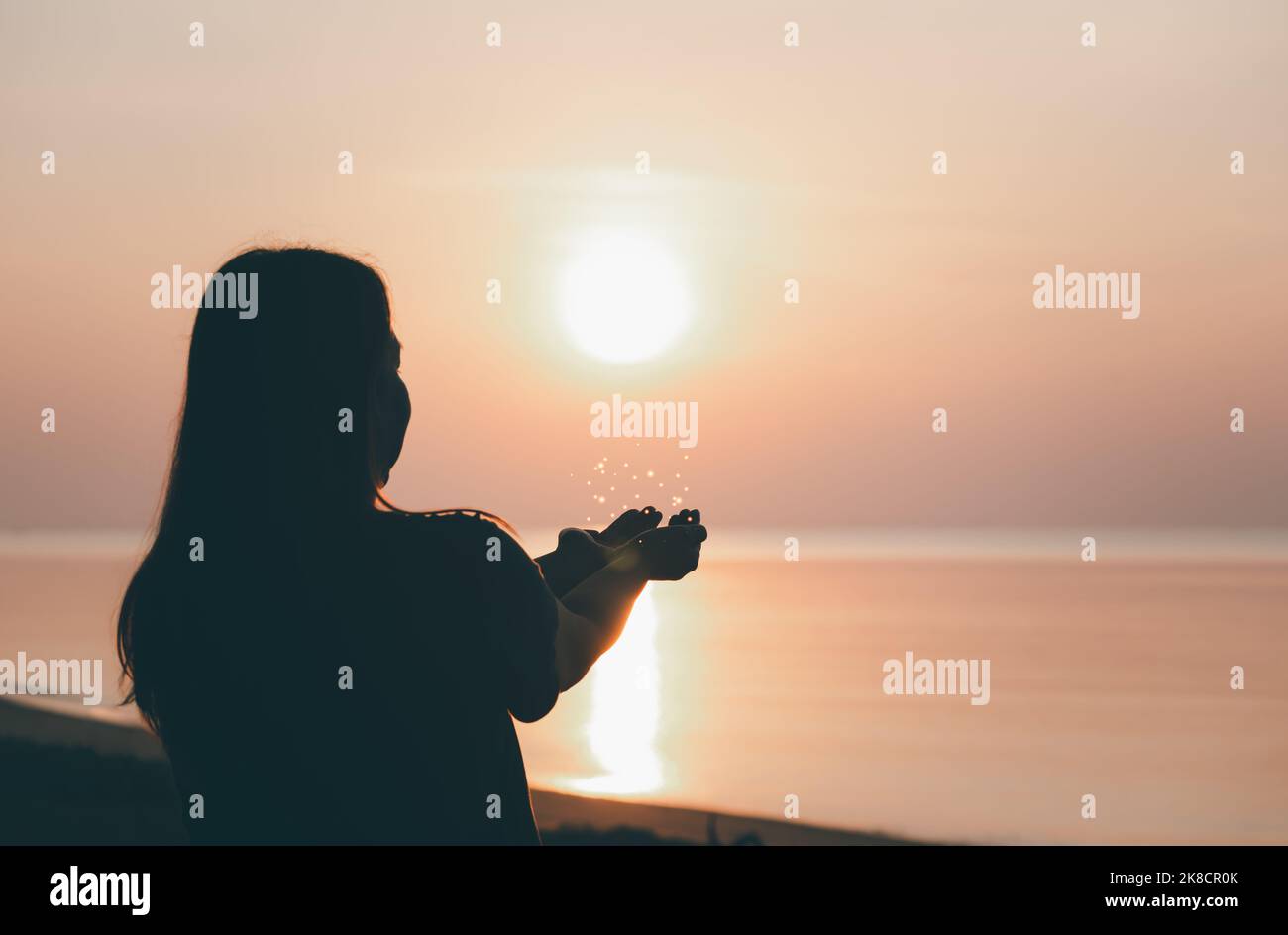 Silhouette of praying hands with God facing the sky at sunrise morning on the beach, Faith in religion and belief in God, Power of hope or love and de Stock Photo