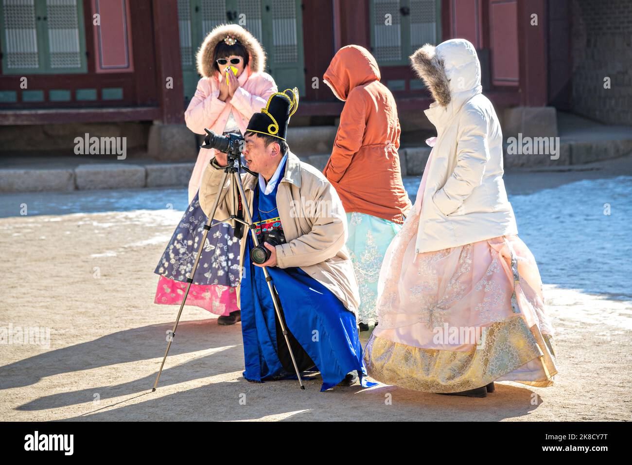 Chinese tourists dressed in traditional Korean costume take photos of each other at the Geunjeong-jeon or Throne Hall, at the Gyeongbokgung Palace in Seoul, South Korea. Stock Photo