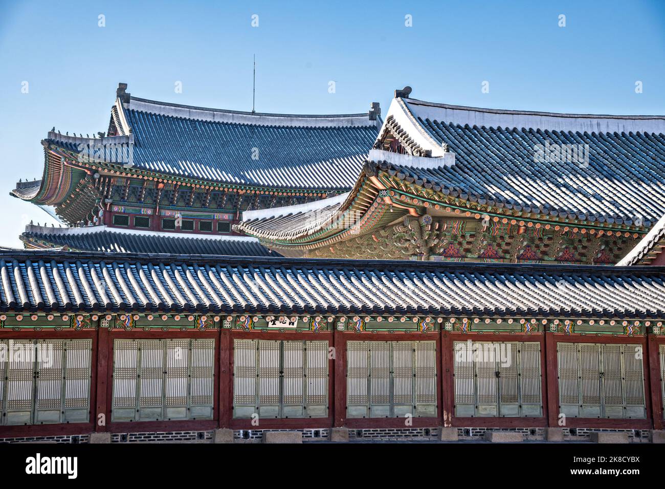 Traditional Korean roofs dusted with snow at the Gyeongbokgung Palace during winter in Seoul, South Korea. Stock Photo