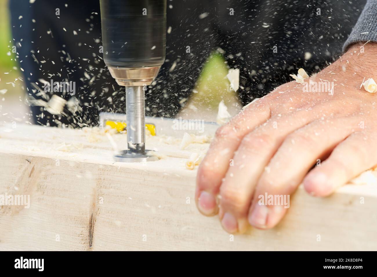 Carpenter drilling holes in the wood beam. wooden frame domestic house