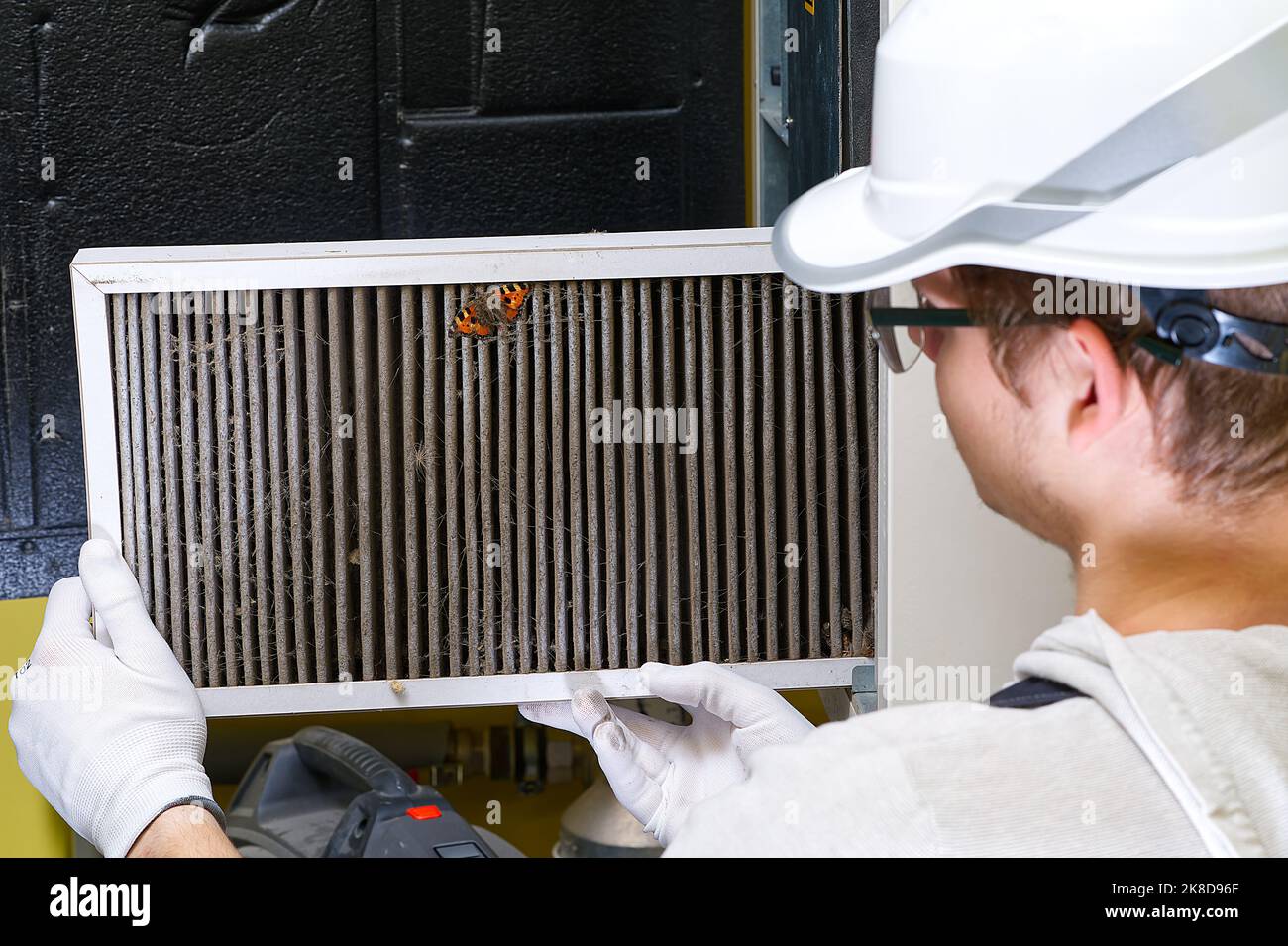 hvac filter replacement home central air system. servicemen changing filter in furnace Stock