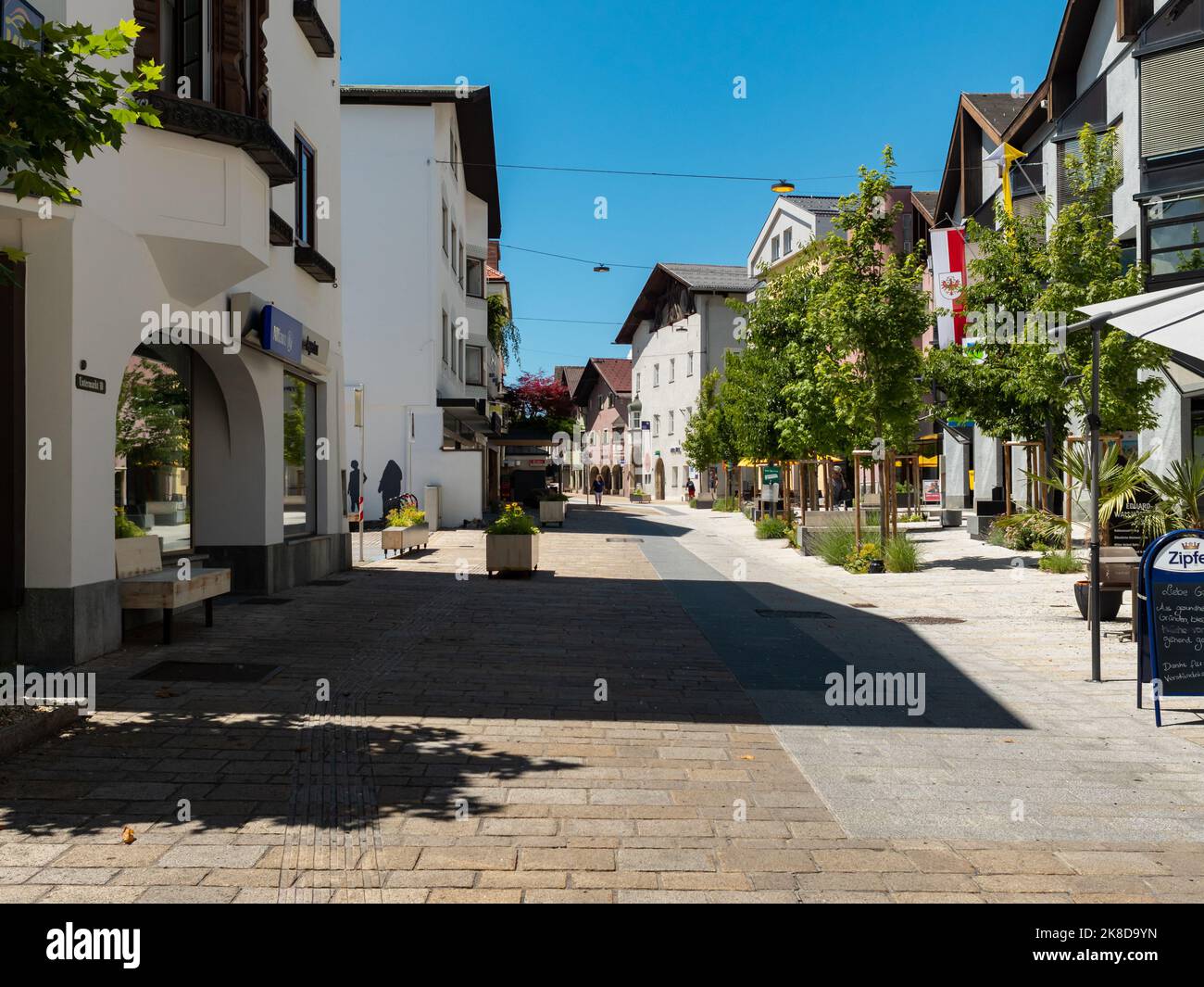 Telfs Untermarkt pedestrian zone on a sunny summer day. Beautiful architecture is in the inner city. Green leaves on the trees and the sky is blue. Stock Photo