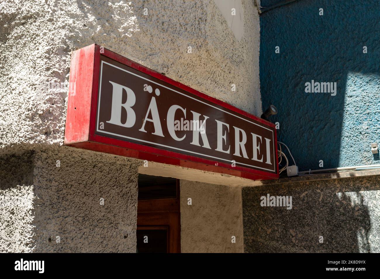 Bäckerei (Bakery) lettering on a building exterior. Advertising of a small business in a town. The big sign on a wall leading to the entrance. Stock Photo