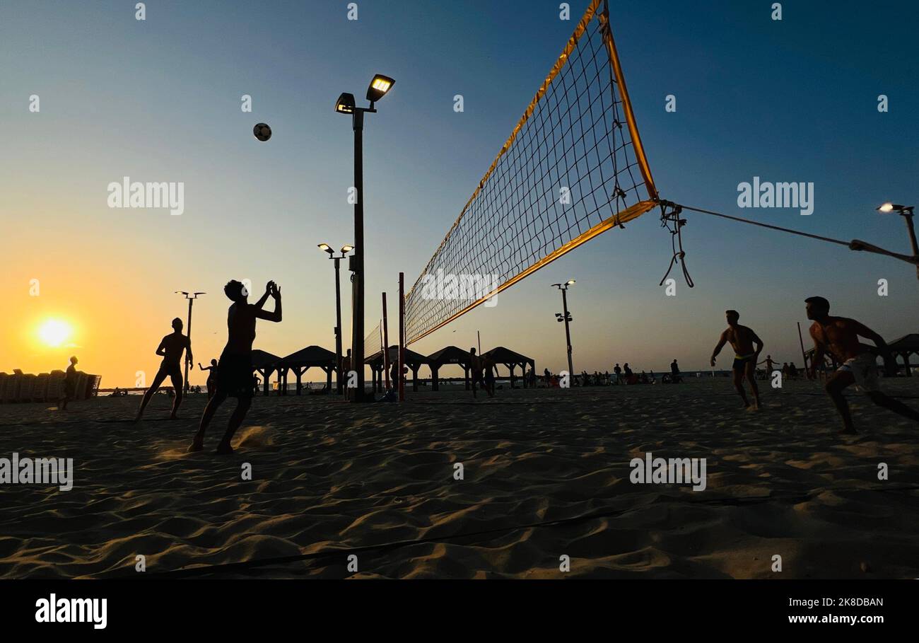 Tel Aviv. 22nd Oct, 2022. People play on the beach at sunset in the ...