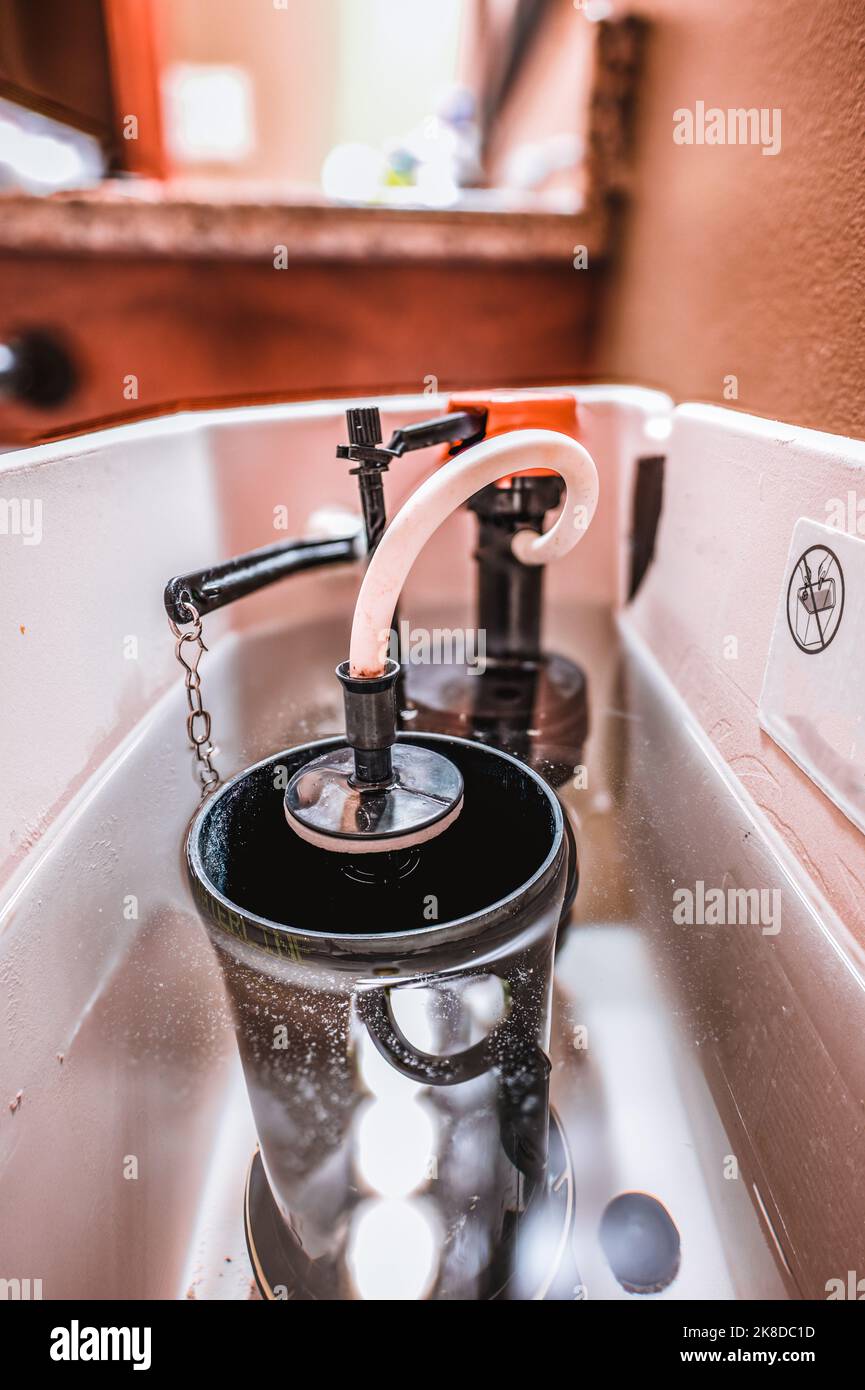 Inside water tank of toilet with float raised Stock Photo
