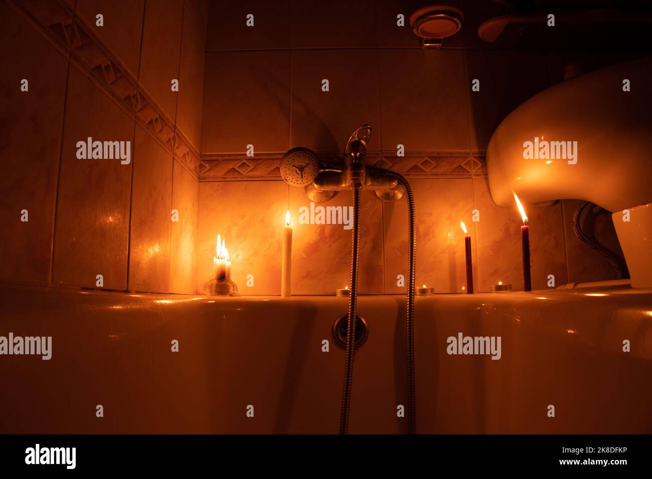 Candles in the bathroom in a dark apartment in Ukraine, Ukraine without electricity due to the war, turned off the light Stock Photo