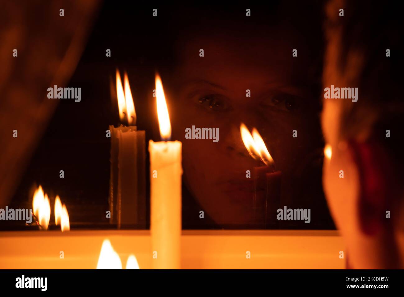 The girl's face put candles on the window in an apartment in Ukraine