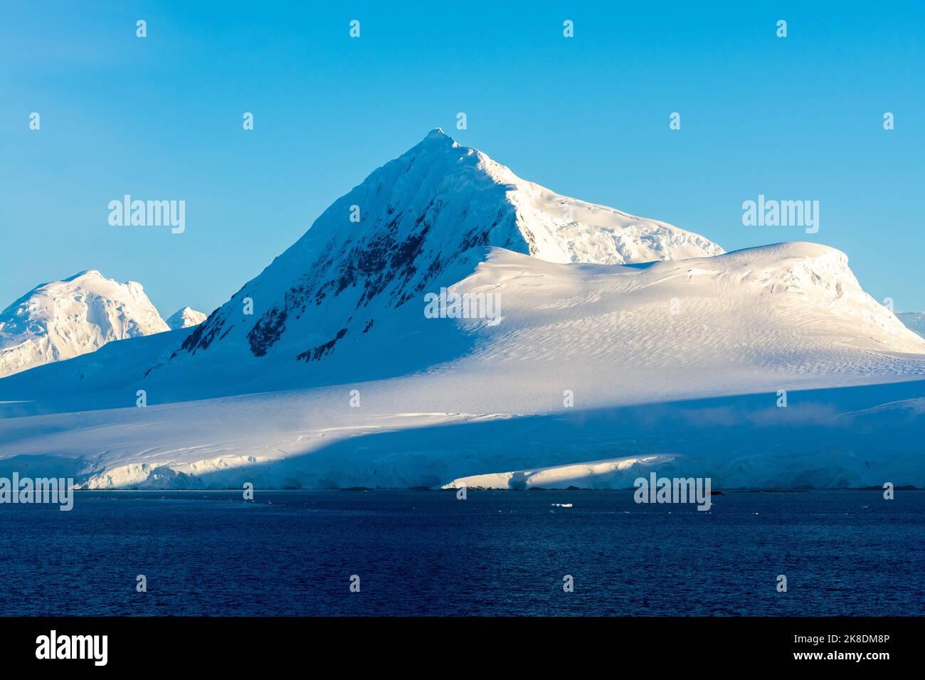 early morning sun lights up mt. william on anvers island. antarctic ...