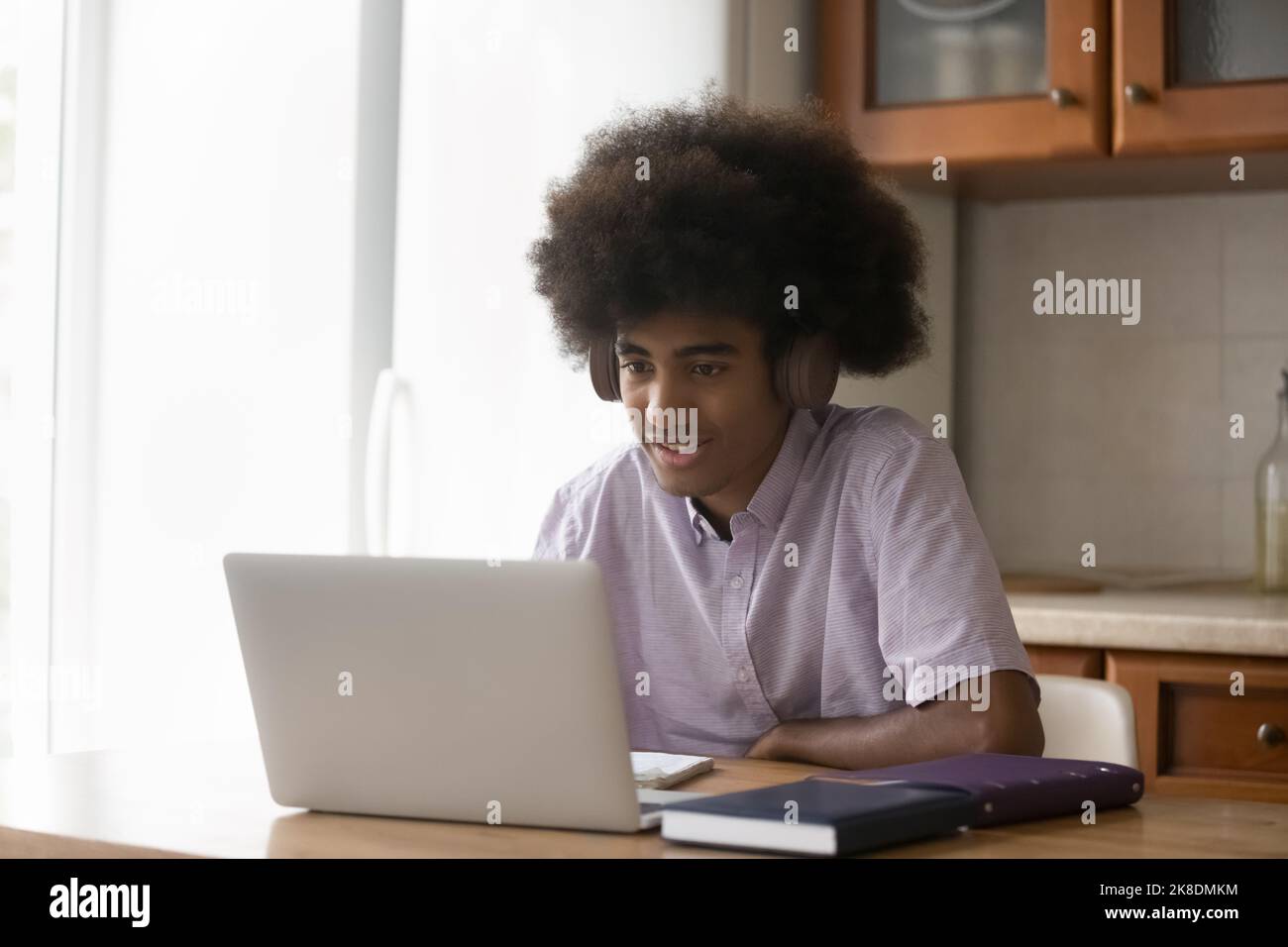 African student guy wear headphones use laptop studying at home Stock ...