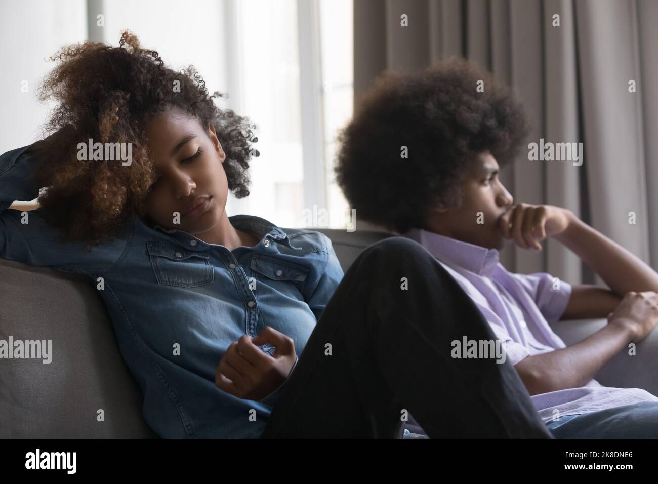 African couple sit on sofa apart after quarrel Stock Photo - Alamy