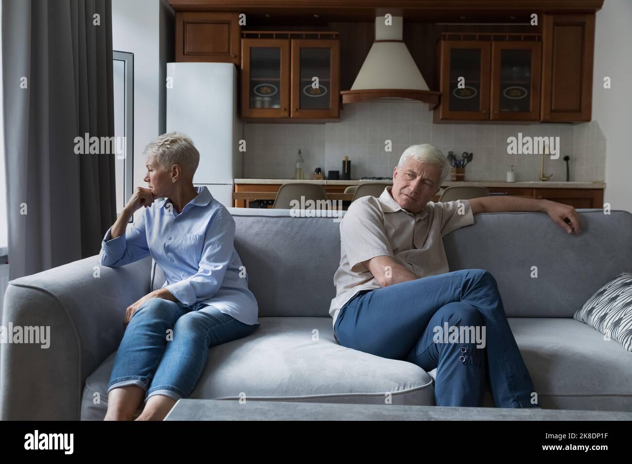 Older silent couple after quarrel sit on sofa apart Stock Photo