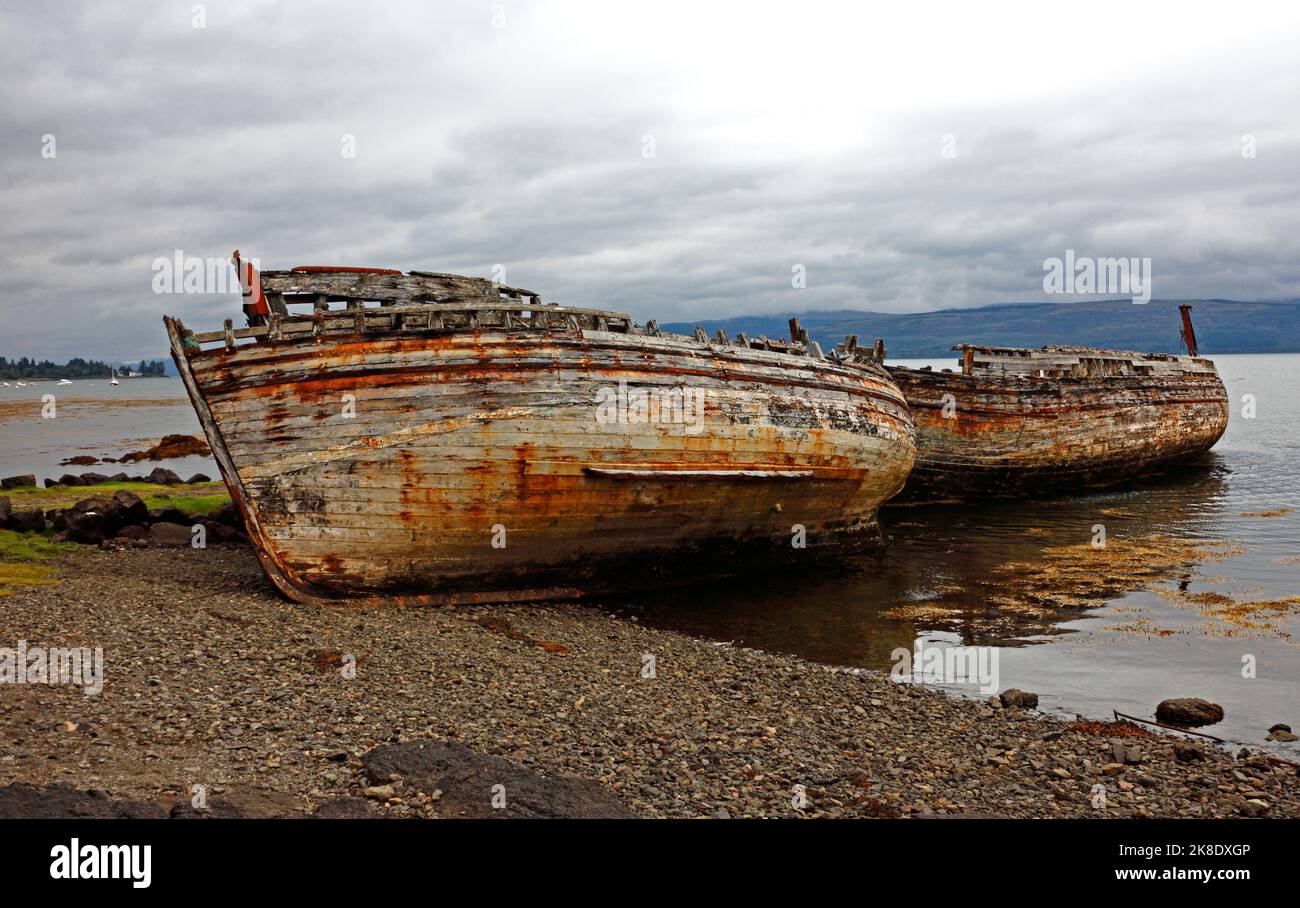 Old decaying fishing boats beached by Salen Bay and the A849 road on the east coast of Mull at Salen, Isle of Mull, Argyll and Bute, Scotland. Stock Photo