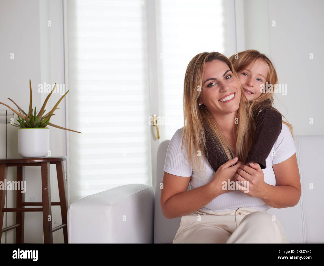 Young beautiful mother playing with daughter in livingroom Stock Photo