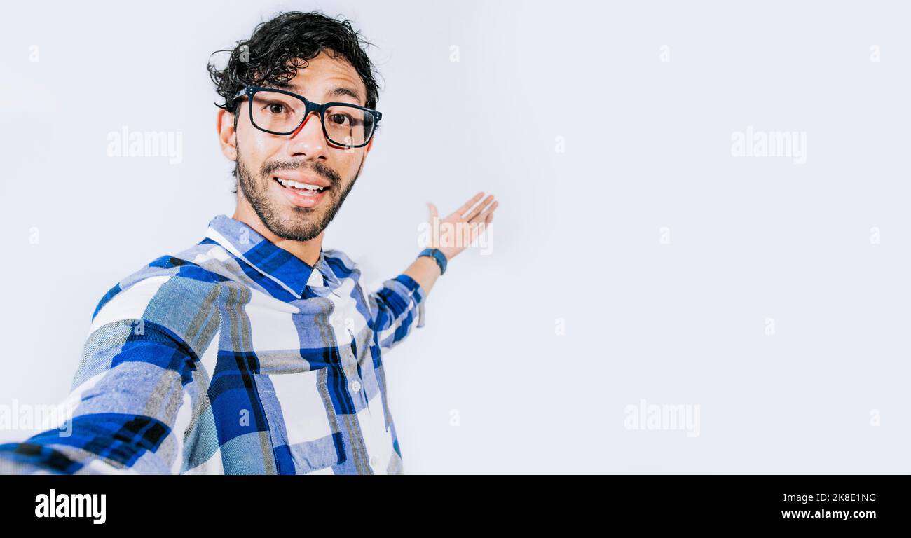 Man pointing back and presenting a product, Young man welcoming you isolated, person welcoming you with one hand. Friendly man inviting you to come Stock Photo